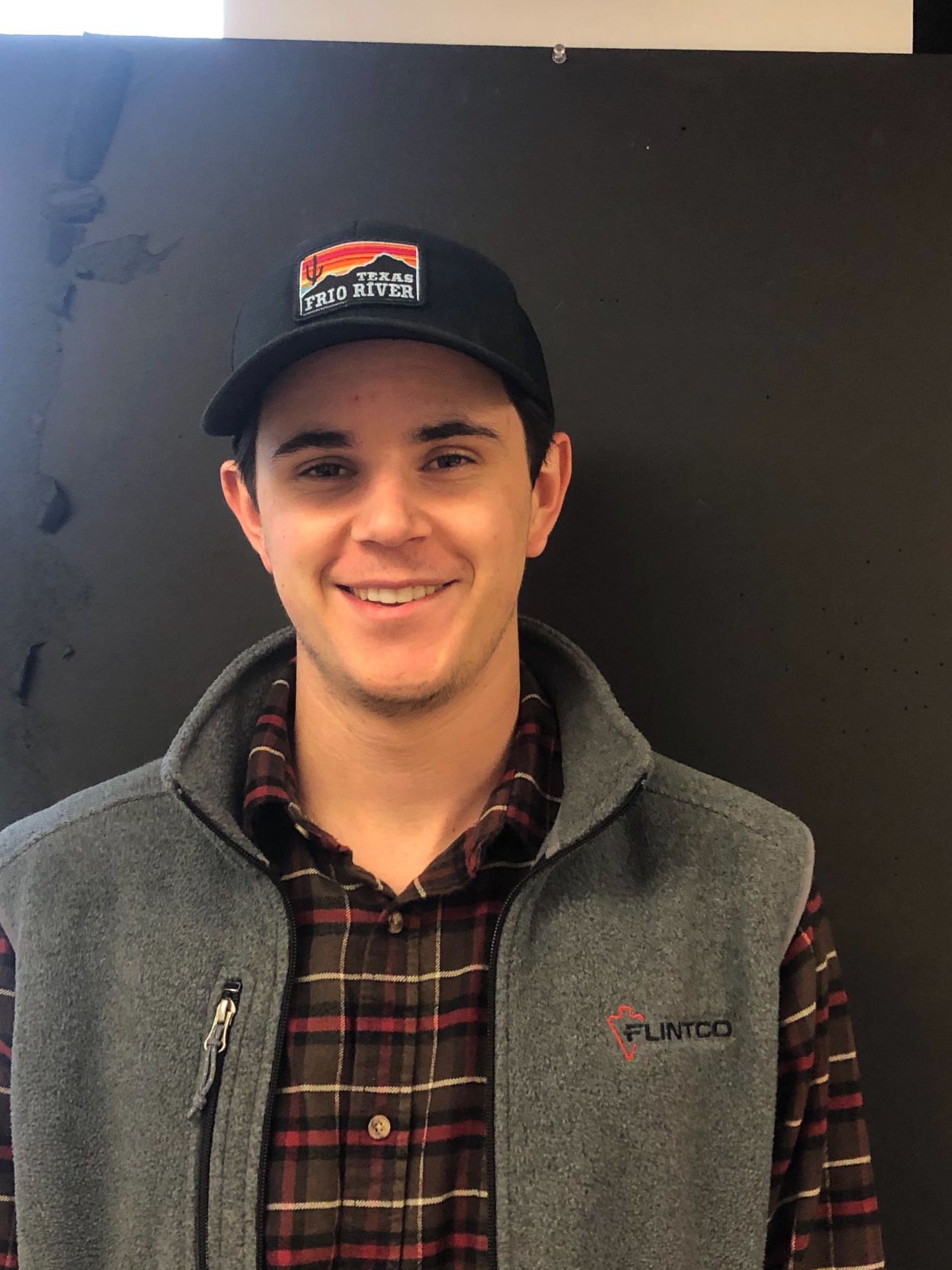 Second-year industrial design student Griffin Garbutt smiles as he stands in front of a wall